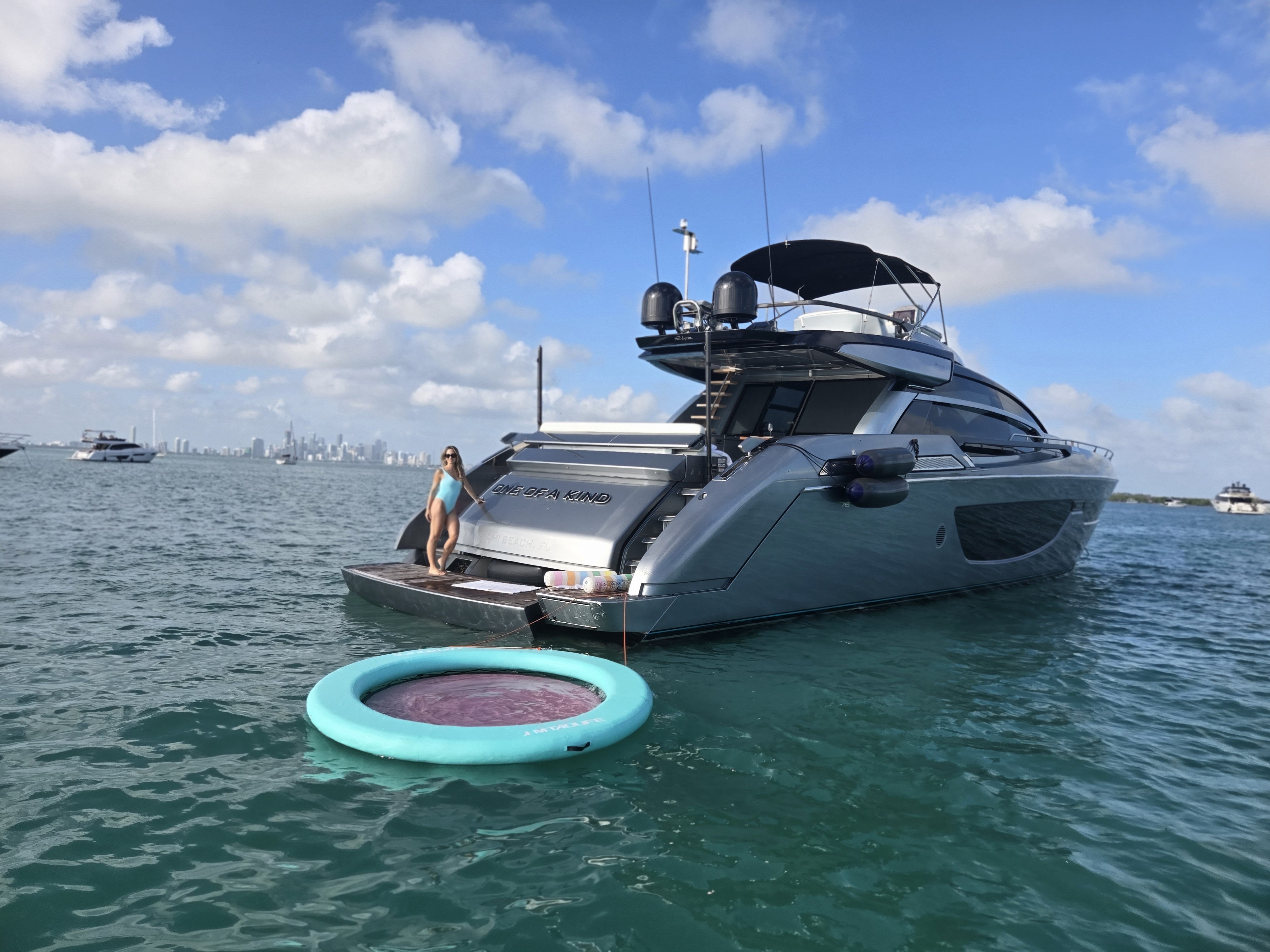 Yate fondeado en aguas turquesa con flotador y skyline de Miami