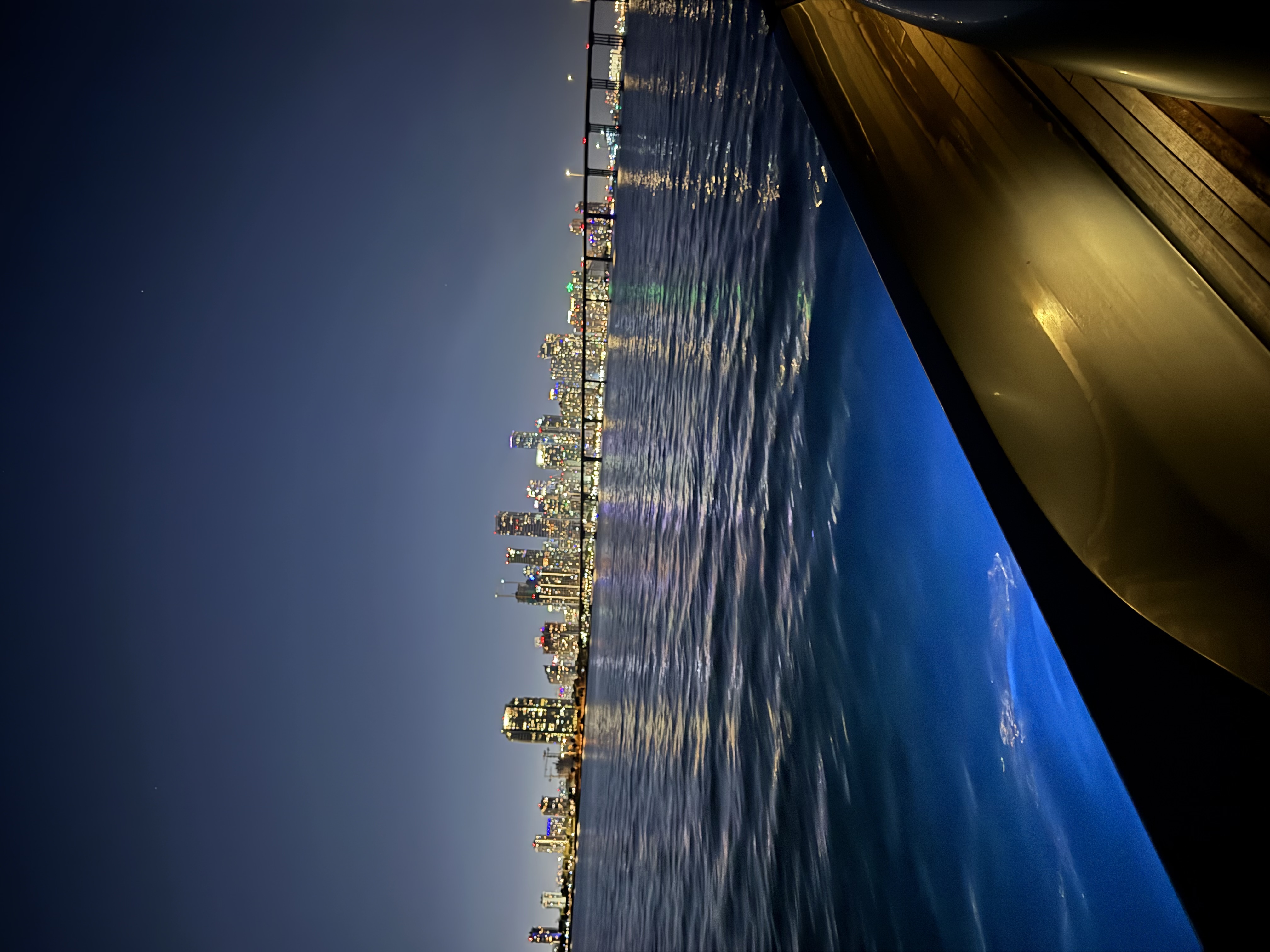 El yate de noche frente al skyline de Miami y el puente de Rickenbacker